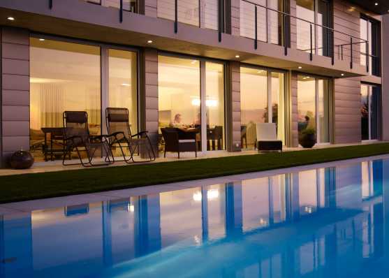 Luxus Gartenschwimmbad mit Überlaufrinne und Folienauskleidung vor Villa