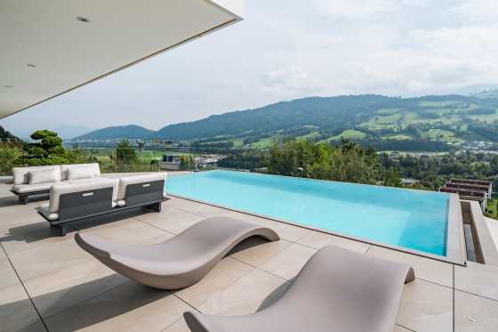 Beton-Schwimmbecken am Hügel mit luxuriösen Sonnenliegen