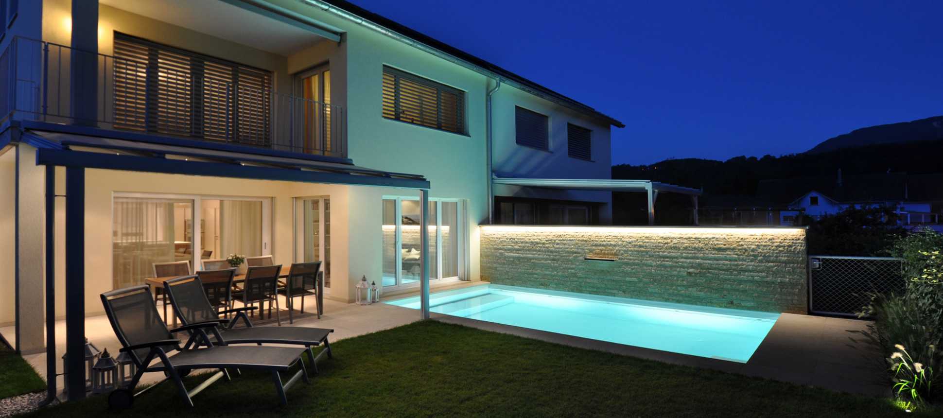 Haus mit Swimmingpool beleuchtet
